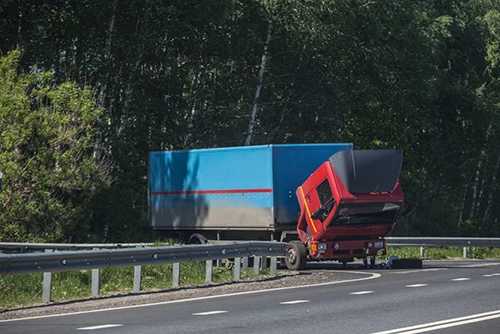 Commercial vehicle truck stuck on the guard rail on the side of the road